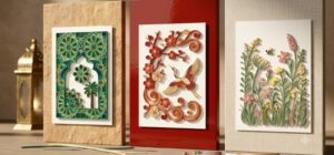 Three handmade Vietnamese quilling cards localised by market: an emerald and gold geometric star card with a date palm for the Gulf, a red and gold plum blossom and crane card for East Asia, and a pastel wildflower meadow card with a bee for Europe